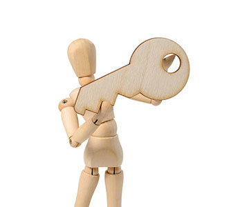 Artist wood figure model holding large wooden key