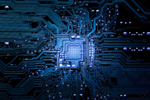 Closeup of electronic circuit board in blue tones, representing Paper-Less MES overview page