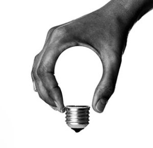 Hand in grasping pattern angled to form top of light bulb
