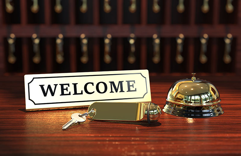 Welcome. Polished reception desk with sign, bell and key.