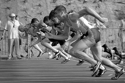 Track Runners, still in lean, having just started race. Image in Black & white