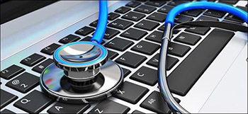 Computer Health, blue stethoscope laying on laptop